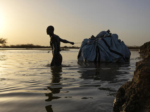Man carries belongings through flood waters Man carries belongings through flood waters